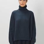 Alternate front view of ls t-neck raglan sweater on model wearing navy pants, against a white background.