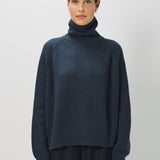 Alternate front view of ls t-neck raglan sweater on model wearing navy pants, against a white background.