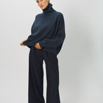 Alternate front view of midnight ls t-neck raglan seater on model wearing navy pants, against a white background.