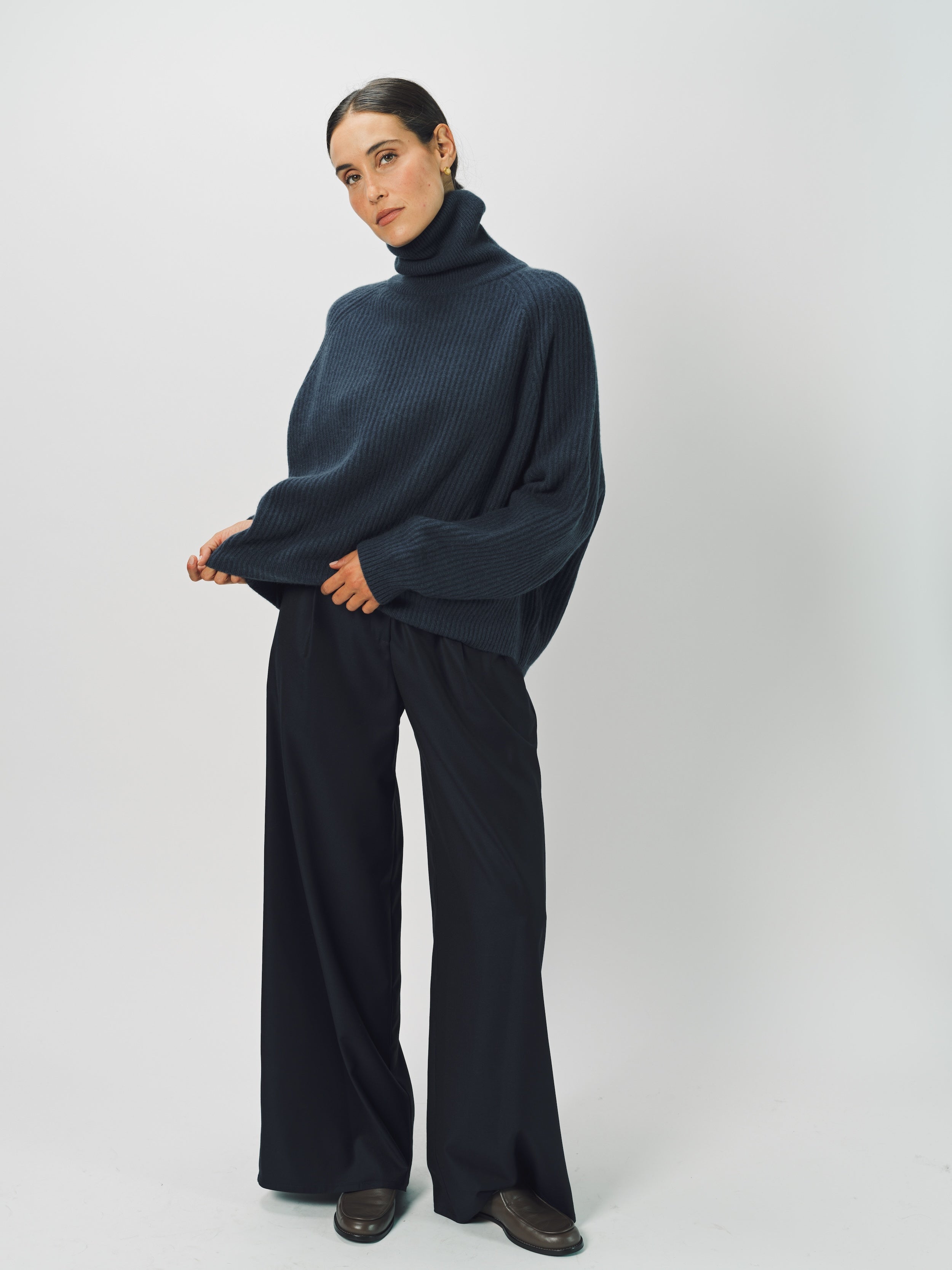 Alternate front view of midnight ls t-neck raglan seater on model wearing navy pants, against a white background.