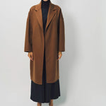 Front view of palissandro oversized coat on model wearing navy turtleneck, pants and loafers, against a white background.