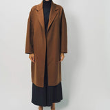 Front view of palissandro oversized coat on model wearing navy turtleneck, pants and loafers, against a white background.