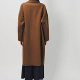Back view of palissandro oversized coat on model wearing navy pants and loafers, against a white background.