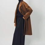 Alternate side view of palissandro oversize coat on model wearing navy turtleneck, pants and loafers, against a white background.