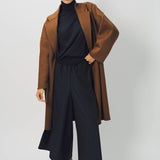 Alternate front view of palissandro oversized coat on model wearing navy turtleneck, pants and loafers, against a white background.