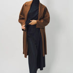 Alternate front view of palissandro oversized coat on model wearing navy turtleneck, pants, and loafers, against a white background.