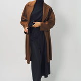 Alternate front view of palissandro oversized coat on model wearing navy turtleneck, pants, and loafers, against a white background.