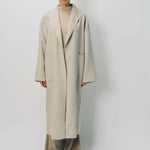 Front view of oatmeal cashmere patch pocket long coat on model wearing beige pants and oatmeal sweater, against a white background.
