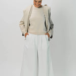 Front view of white cotton gaucho pant on model wearing vanilla top, against white background.