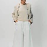 Front view of white cotton gaucho pant on model wearing vanilla top, against white background.