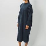 Side view of pacific iconic cashmere dress on model wearing loafers, against a white background.