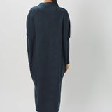 Back view of pacific iconic cashmere dress on model wearing loafers, against a white background.