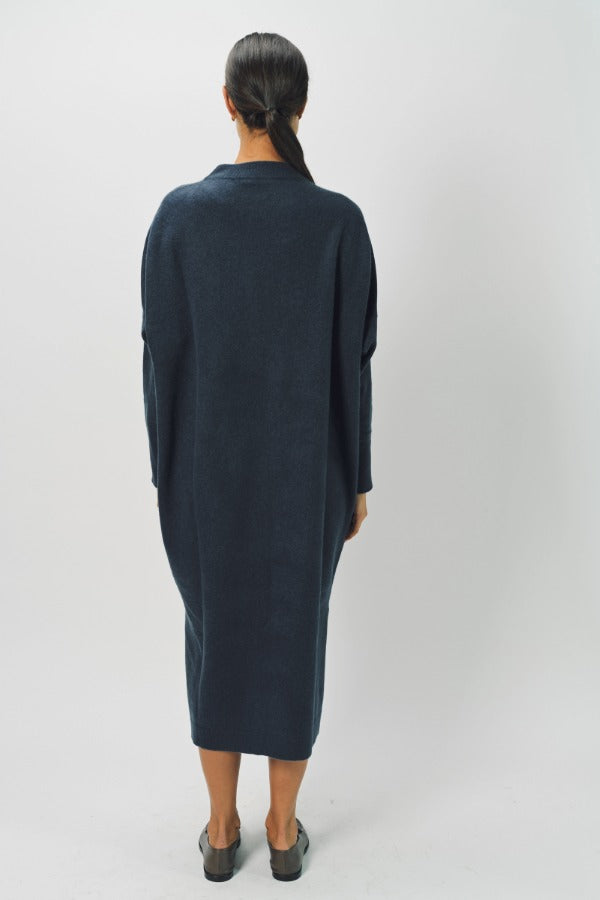 Back view of pacific iconic cashmere dress on model wearing loafers, against a white background.