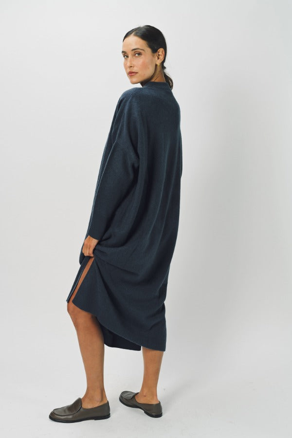 Alternate side view of pacific iconic cashmere dress on model wearing loafers, against a white background.