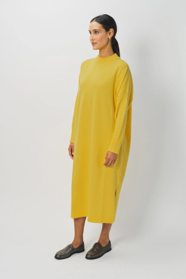 Side view of sunray iconic cashmere dress on model wearing loafers, against a white background.