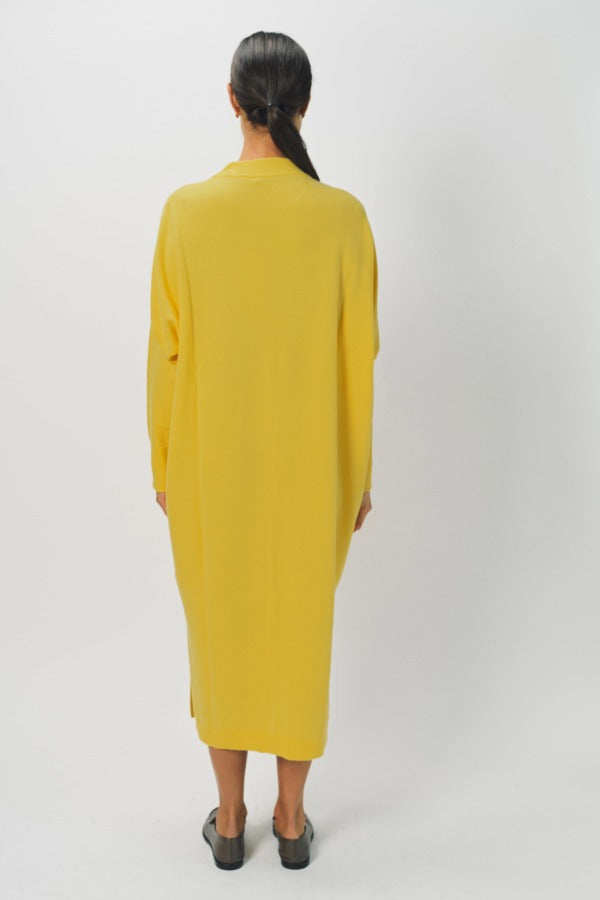 Back view of sunray iconic cashmere dress on model wearing loafers, against a white background.