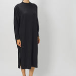Front view of black wood iconic cashmere dress on model wearing loafers, against a white background.