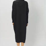 Back view of black wood iconic cashmere dress on model wearing loafers, against a white background.