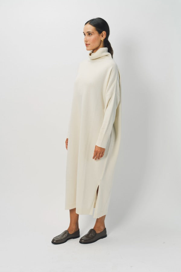 Side view of bone iconic cashmere t-neck dress on model wearing loafers, against a white background.