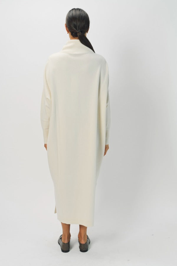 Back view of bone iconic cashmere t-neck dress on model wearing loafers, against a white background.