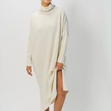Alternate front view of bone iconic cashmere t-neck dress on model wearing loafers, against a white background.