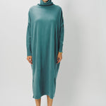 Front view of norfolk blue iconic cashmere t-neck dress on model wearing loafers, against a whiter background.