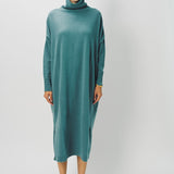 Front view of norfolk blue iconic cashmere t-neck dress on model wearing loafers, against a whiter background.