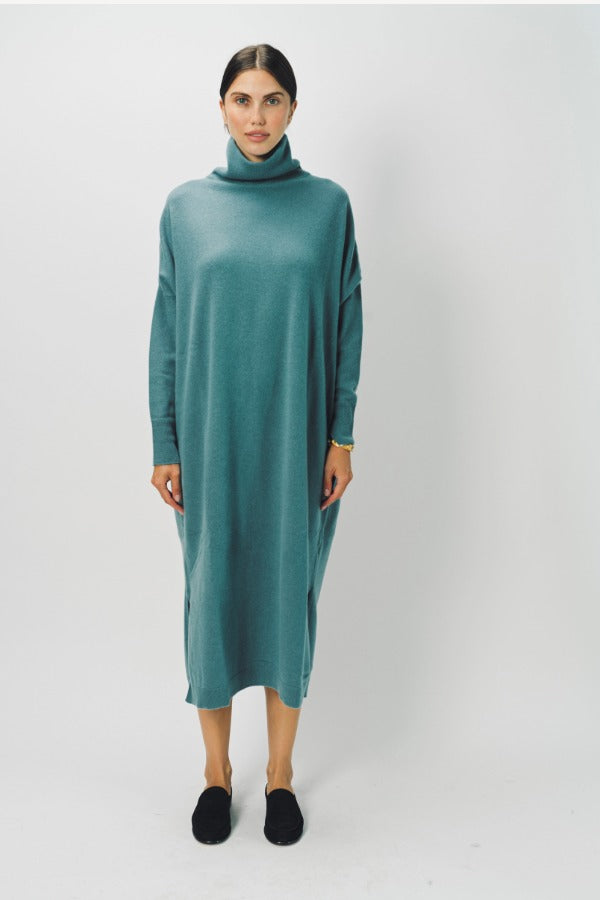 Front view of norfolk blue iconic cashmere t-neck dress on model wearing loafers, against a whiter background.