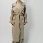 Front view of sand light cashmere trench coat on model wearing sand pants and sweater, against a white background.