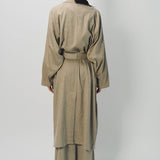 Back view of sand light cashmere trench coat on model wearing sand pants, against a white background.