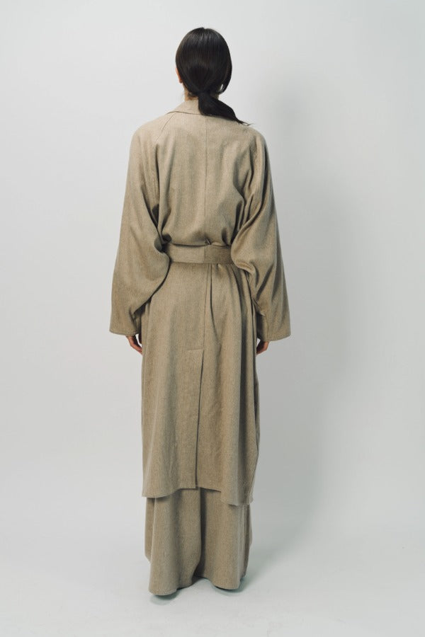 Back view of sand light cashmere trench coat on model wearing sand pants, against a white background.