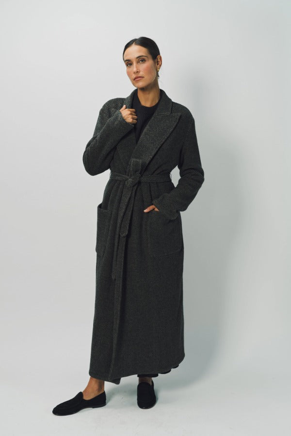 Alternate front view of brown long cashmere jersey coat on model wearing black shirt and loafers, against a white background.