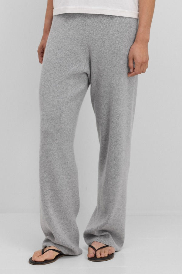 Front view of grey no 320 rush trouser on model wearing white t-shirt and sandals, against a white background.