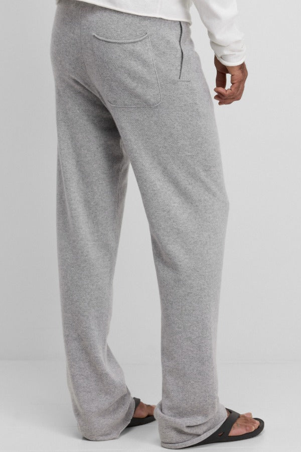 Back view of grey no 320 rush trouser on model wearing white t-shirt and sandals, against a white background.
