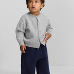 Front view of grey no 440 toddler cardigan on model wearing navy pants, against a white background.