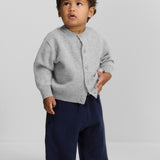 Front view of grey no 440 toddler cardigan on model wearing navy pants, against a white background.