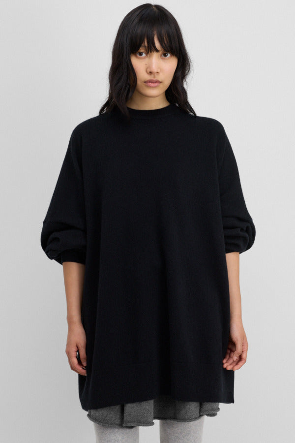 Front view of raven juna sweater on model wearing grey leggings and skirt, against a white background.