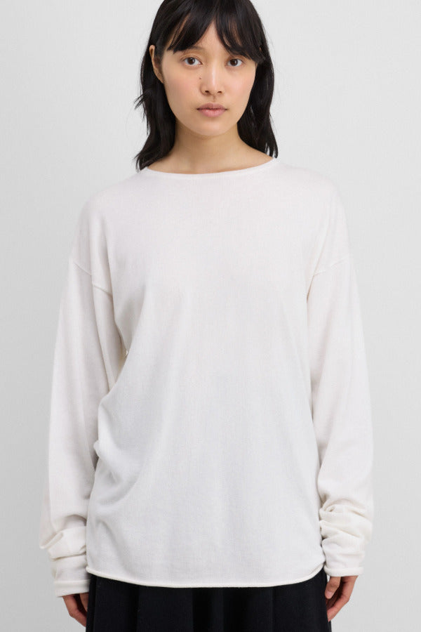 Front view of snow aries sweater on model wearing black trousers, against a white background.