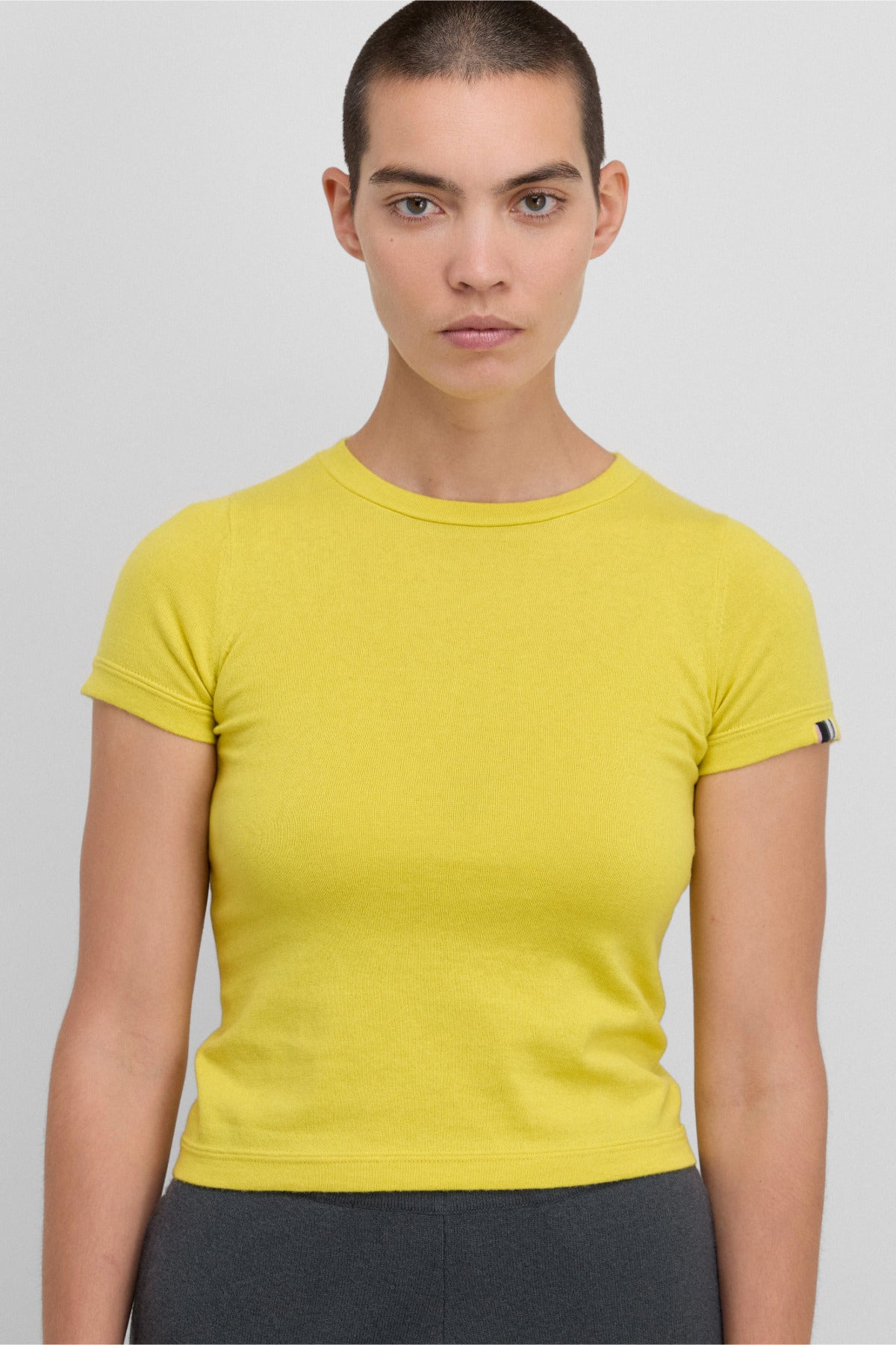 Front view of sunny america top on black haired model wearing grey pants, against white background