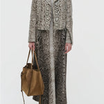 Front view of greyscale aalia dress on model wearing animal print jacket and boots, against a white background.
