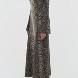 Side view of greyscale aalia dress on model wearing boots, against a white background.