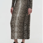Side view of greyscale bragi skirt on model wearing sneakers and a greyscale top, against a white background.