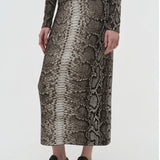 Side view of greyscale bragi skirt on model wearing sneakers and a greyscale top, against a white background.