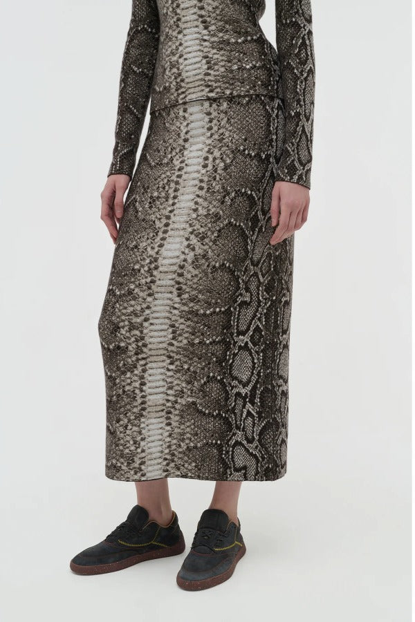 Side view of greyscale bragi skirt on model wearing sneakers and a greyscale top, against a white background.