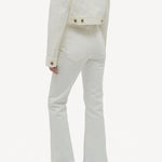 Back view of white bronte jacket on model wearing white pants and boots, against a white background.