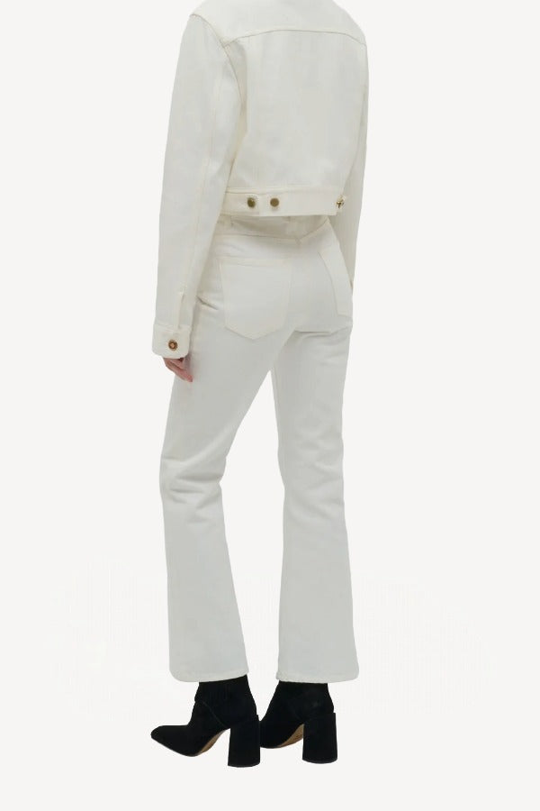 Back view of white bronte jacket on model wearing white pants and boots, against a white background.