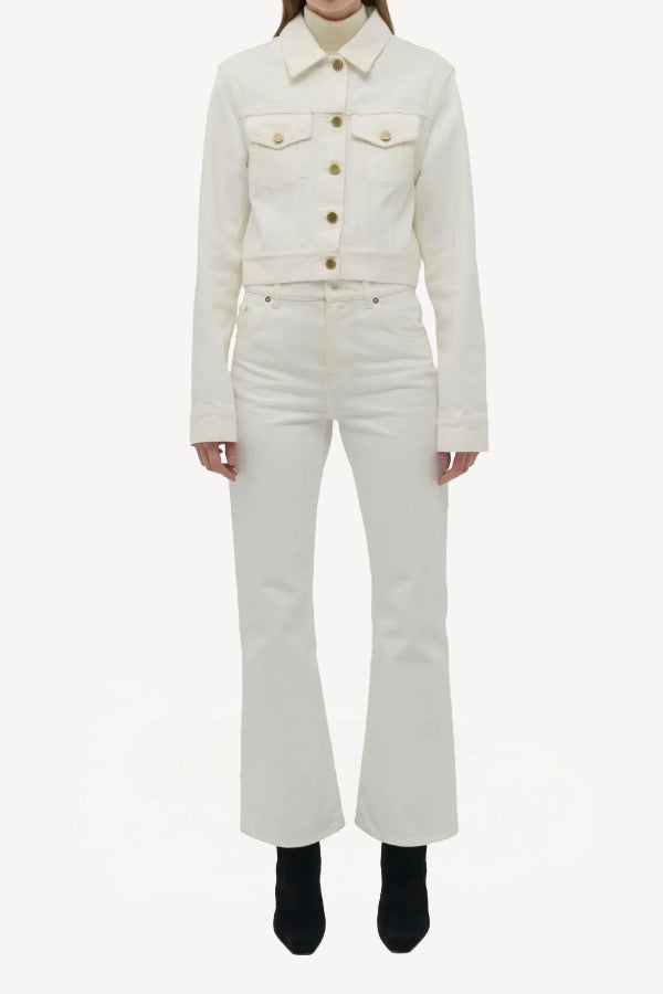 Front view of white ezra bootcut jean on model wearing white jean jacket and boots, against a white background.