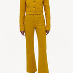 Front view of golden birch ezra bootcut jean on model wearing golden birch jacket and boots, against a white background.