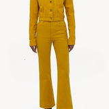 Front view of golden birch ezra bootcut jean on model wearing golden birch jacket and boots, against a white background.