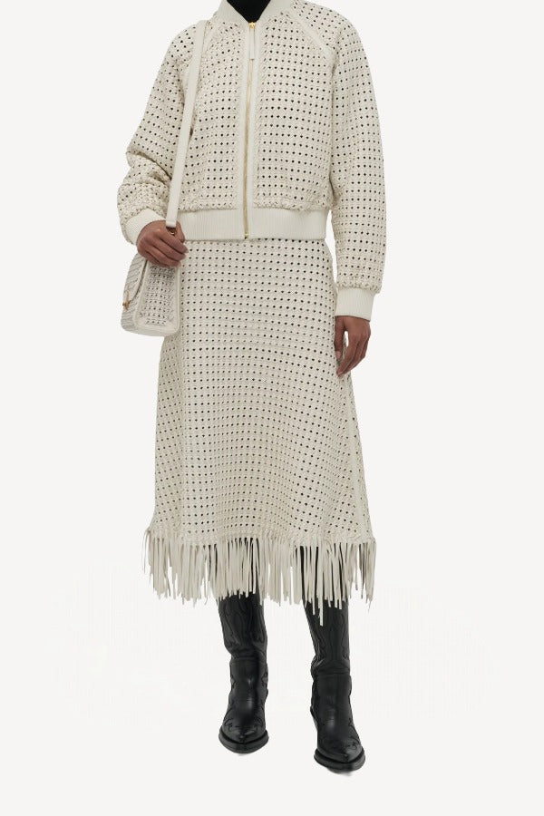 Front view of white odin bomber jacket on model wearing the white Bennie skirt and boots, against a white background.